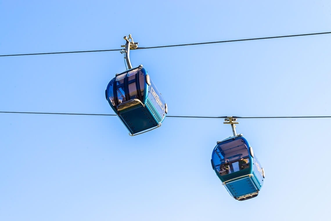 dos teleféricos azules están suspendidos en el aire