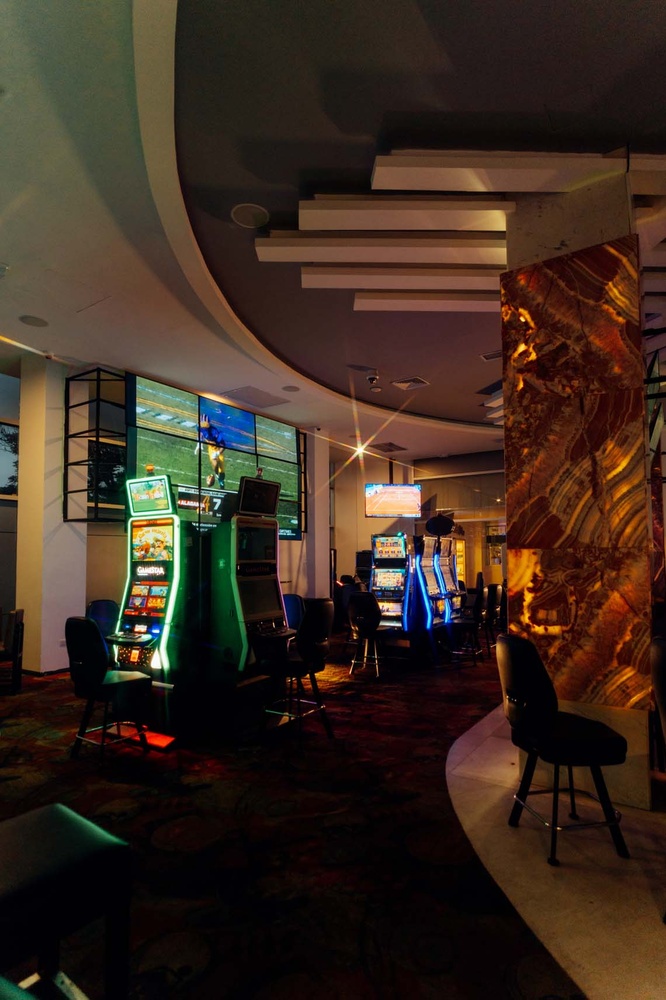 LHVC Resorts: Corpo - Modern casino floor with slot machines and screens.