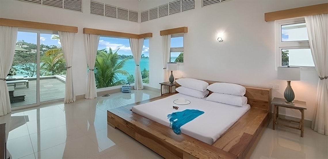 a bedroom with a large bed and a view of the ocean