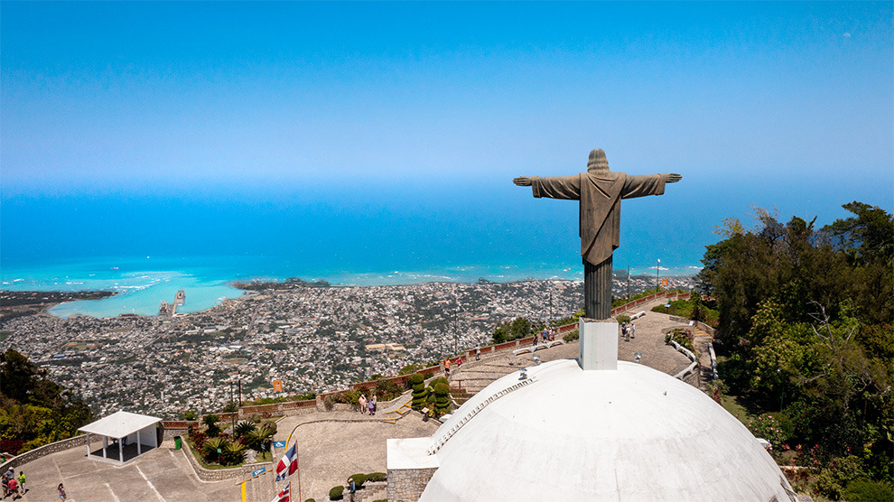 Estatua del Cristo Redentor con vista panorámica deLHVC Resorts: Corpo Santo Domingo y el mar Caribe.