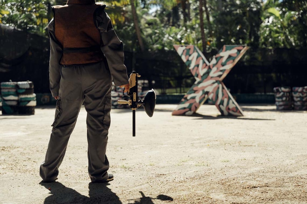LHVC Resorts: Body playing paintball, protective gear, and game field.