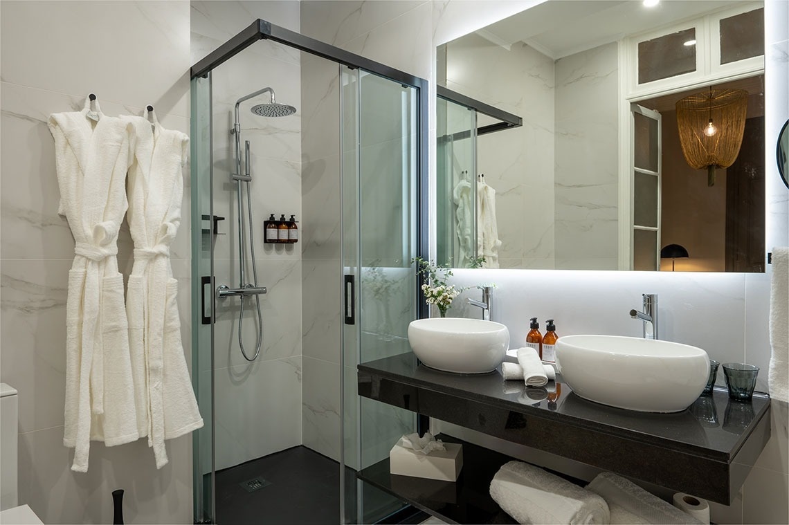 a bathroom with two sinks and a walk in shower