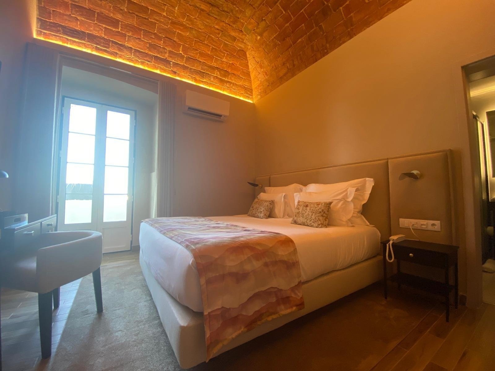 a hotel room with a large bed and a brick ceiling