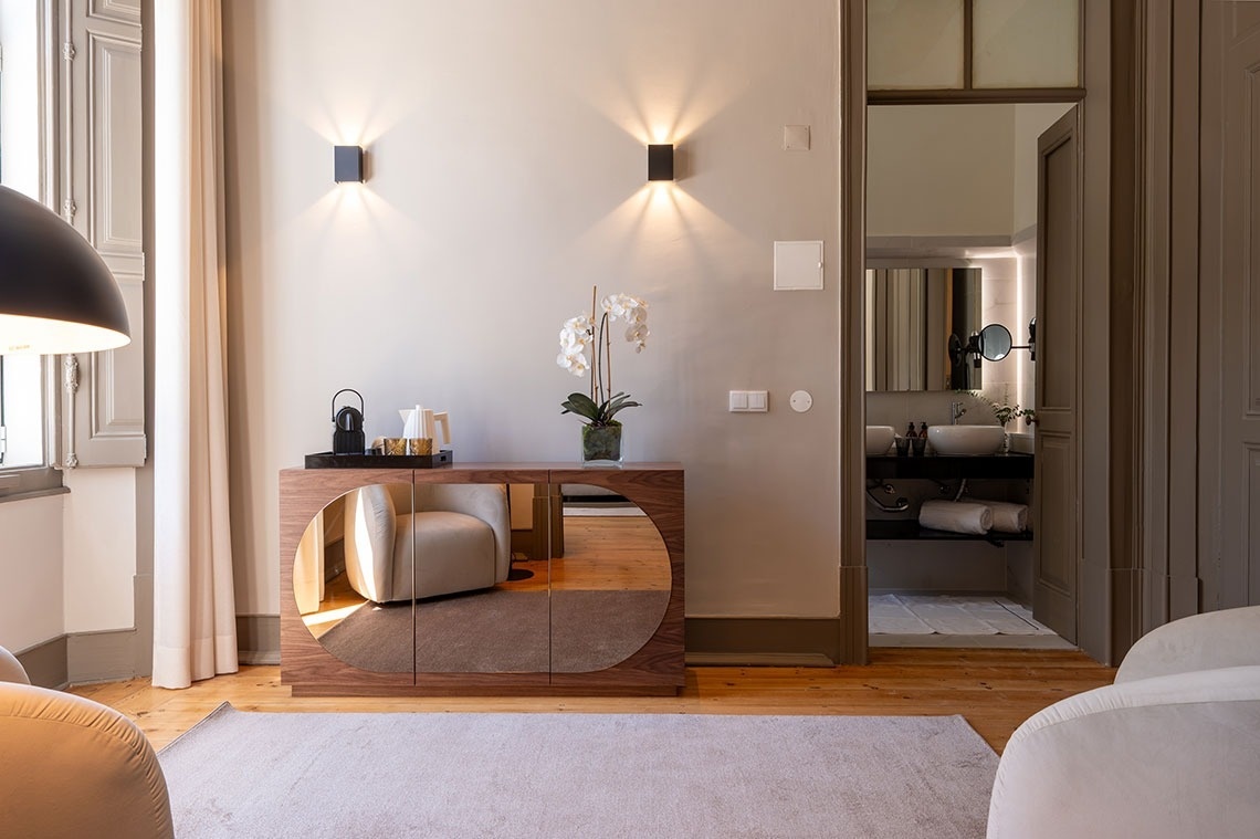 a room with a mirrored cabinet and a chair