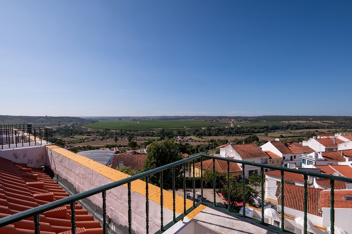 uma varanda com vista para uma pequena cidade