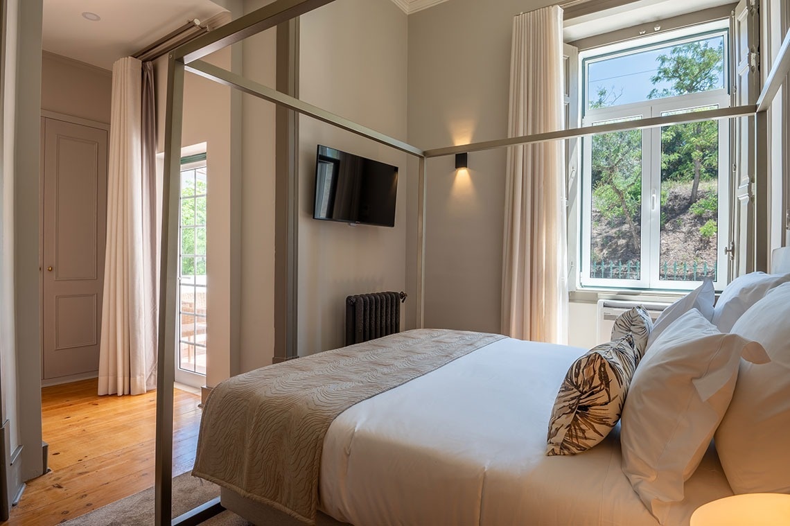 a bedroom with a four poster bed and a flat screen tv