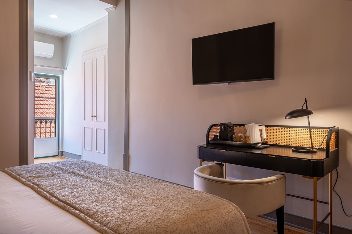 a bedroom with a desk and a flat screen tv