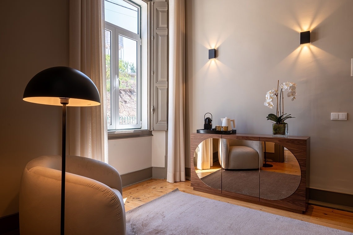 a room with a chair and a mirrored dresser