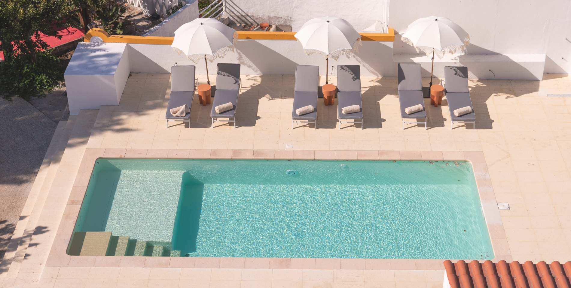 a swimming pool with chairs and umbrellas around it