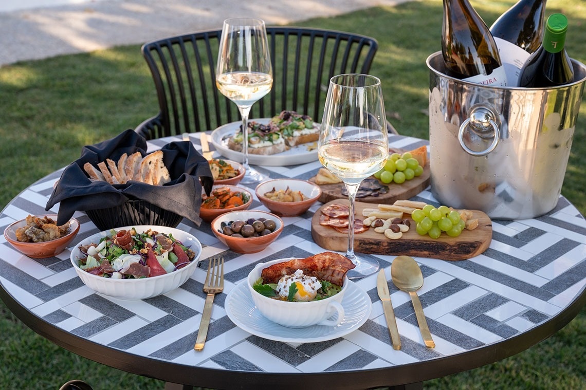uma mesa cheia de comida e bebidas com garrafas de vinho