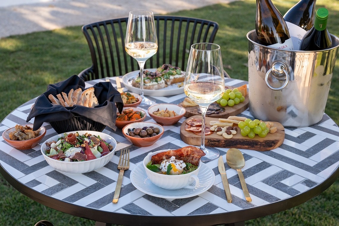 a table with a bucket of wine and a bowl of food