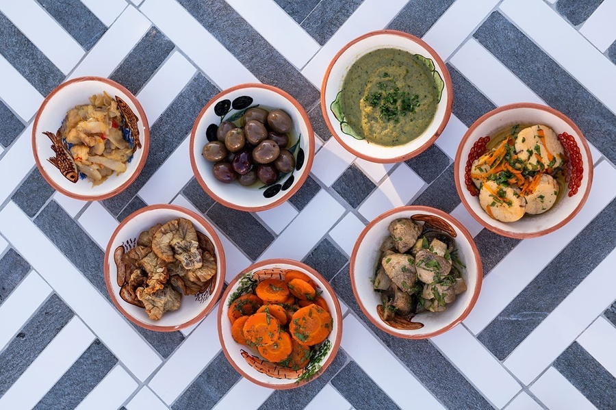 a variety of bowls of food including olives and carrots