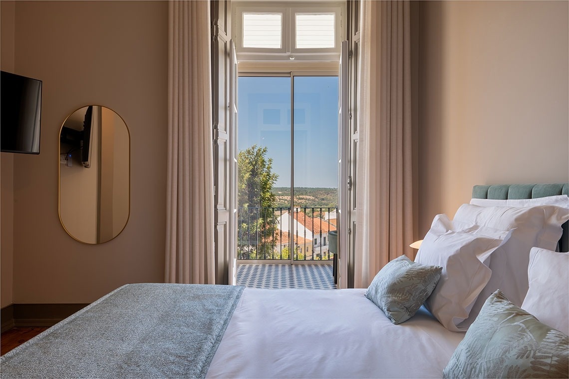 um quarto com uma cama e uma janela com vista para a cidade