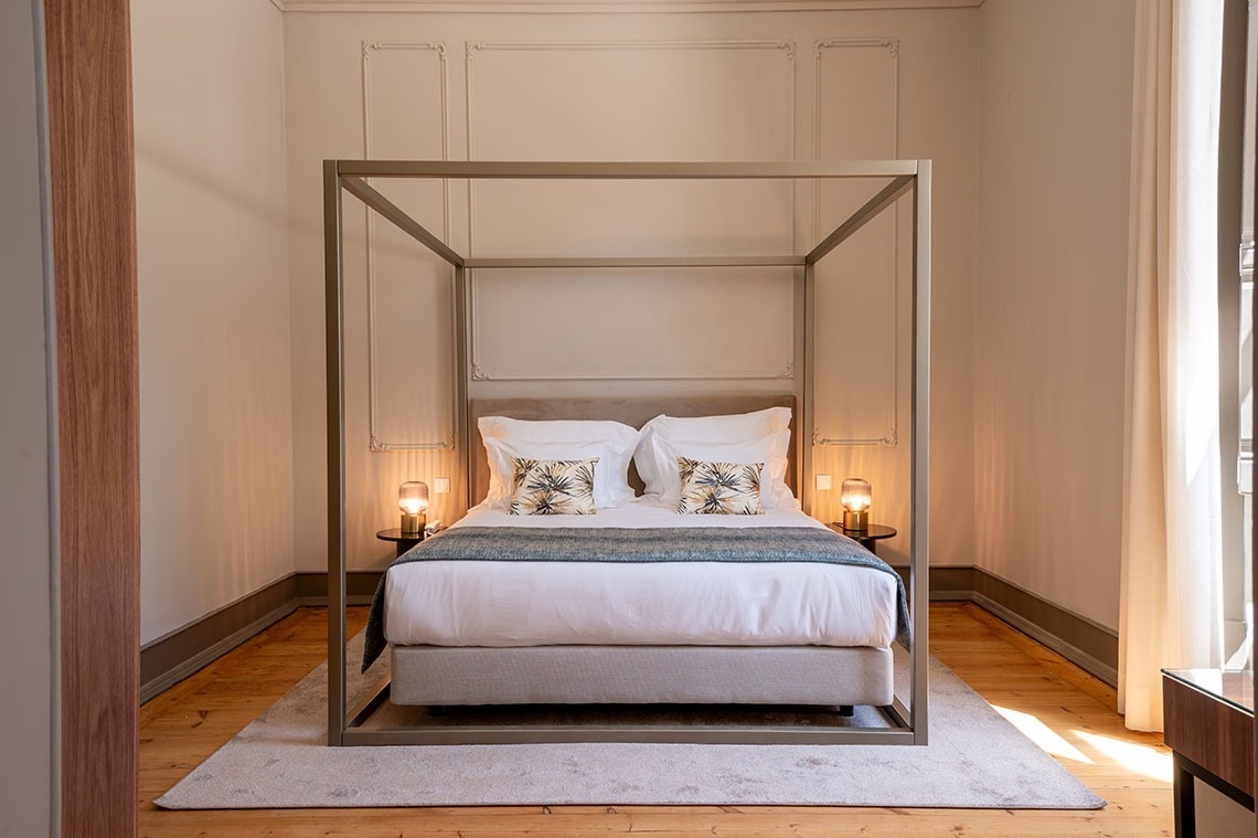 a bedroom with a canopy bed and two lamps