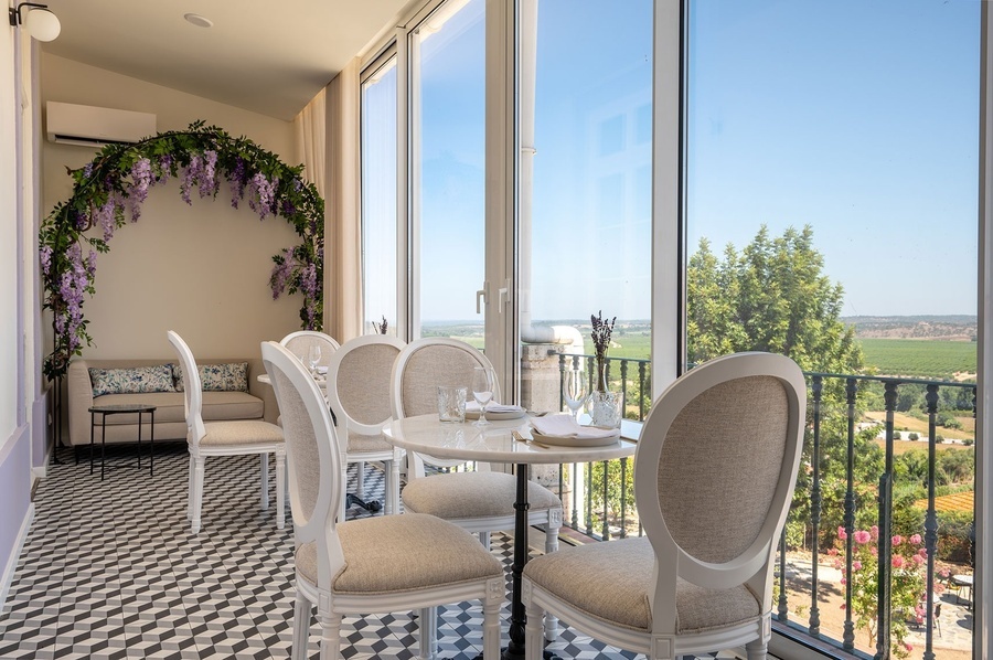 a room with tables and chairs and a large window