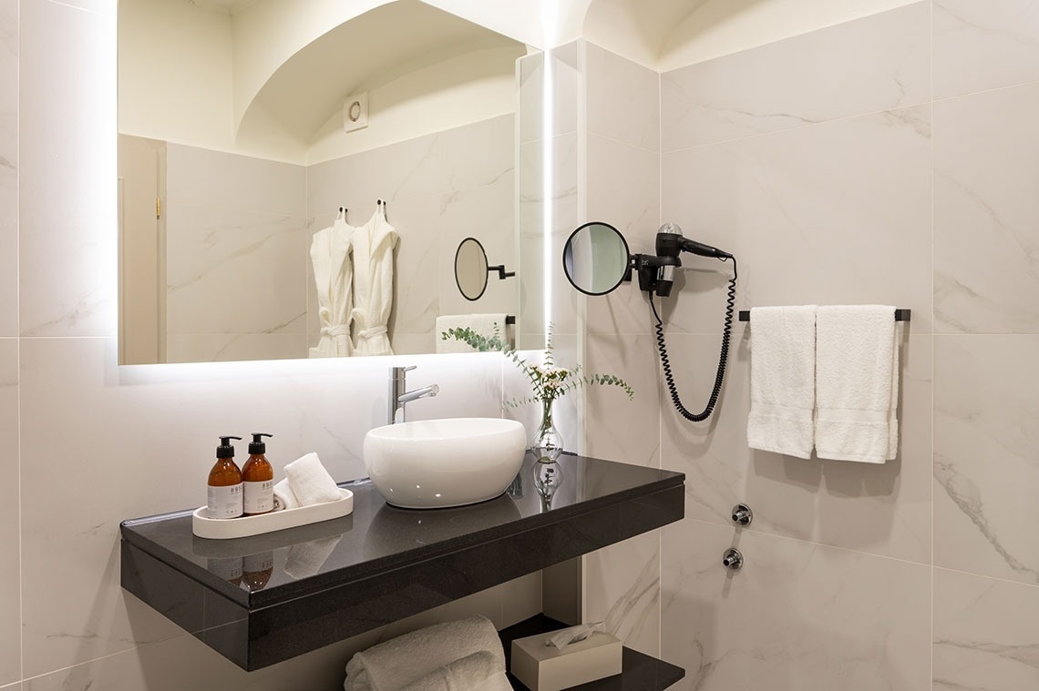 a bathroom with a sink a mirror and a hair dryer