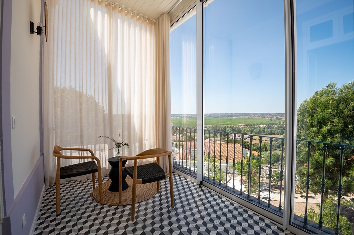 a balcony with two chairs and a table with a view