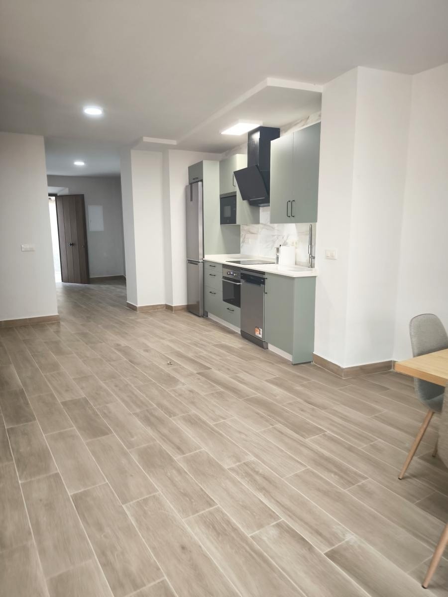 una cocina con piso de baldosas y gabinetes grises