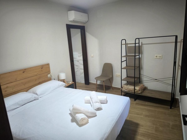 un dormitorio con una cama y una silla y una estantería