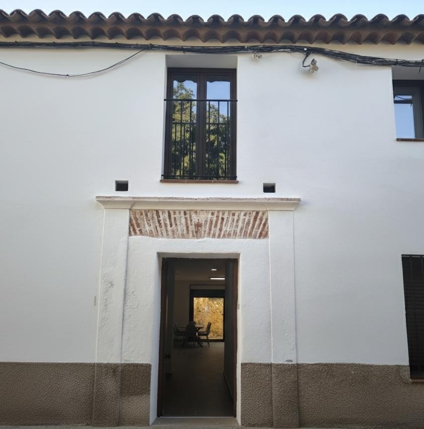 un edificio blanco con una puerta y una ventana