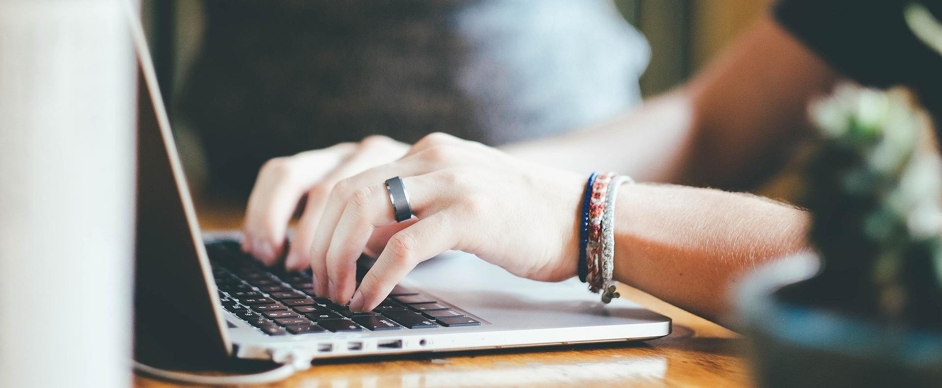 un primer plano de una persona escribiendo en una computadora portátil