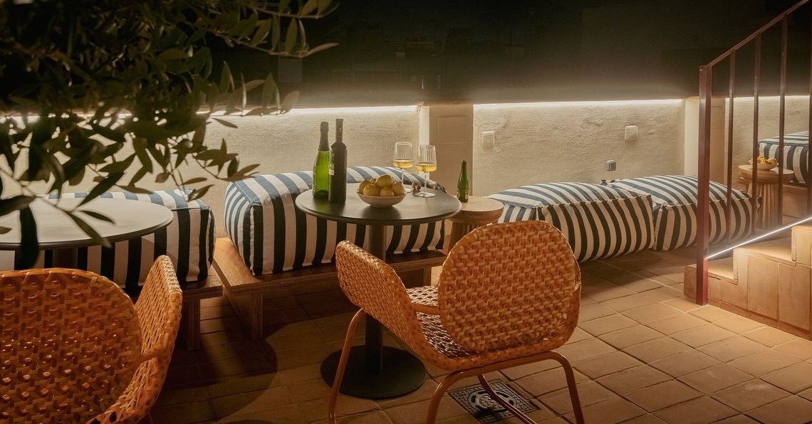 a room with chairs and a table with a chandelier on the wall