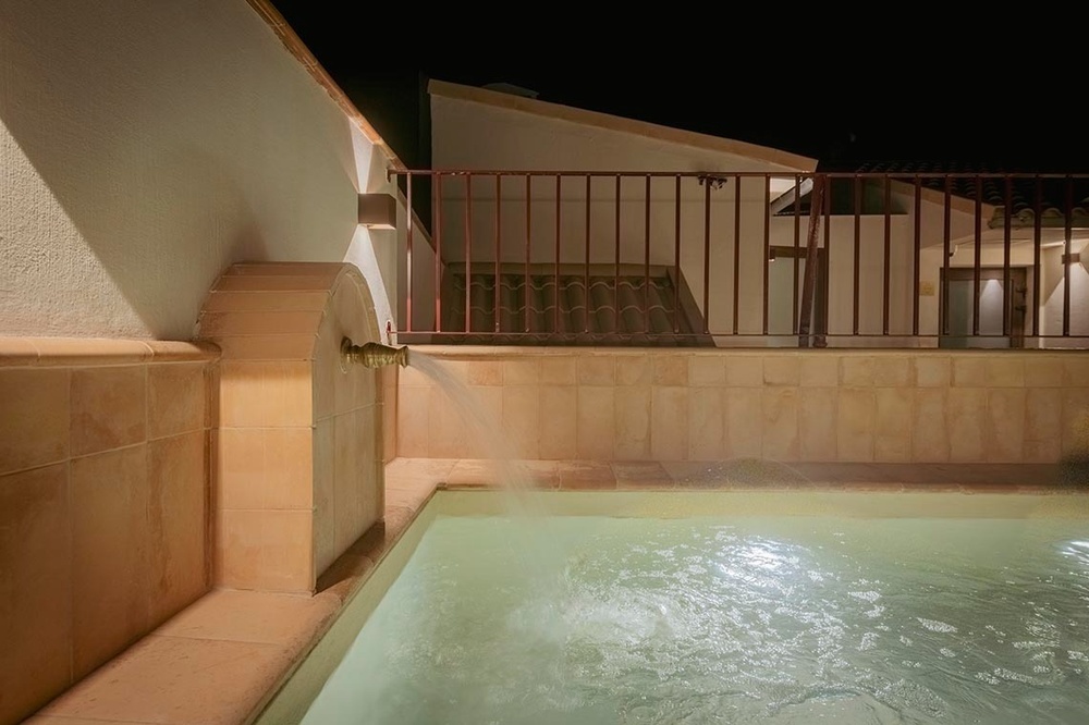una piscina con agua y una fuente en la noche