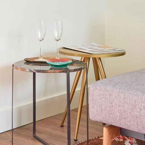 two tables with wine glasses and magazines on them