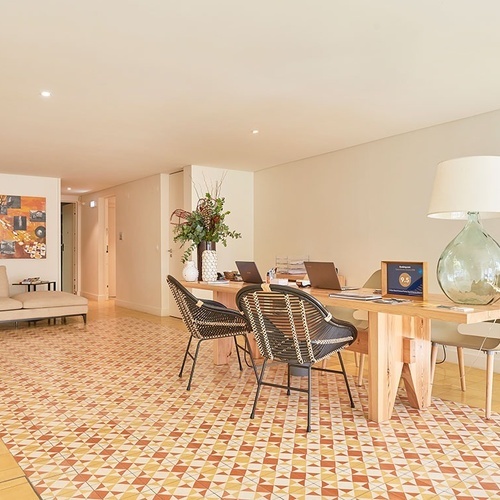 a living room with a table and chairs and a lamp