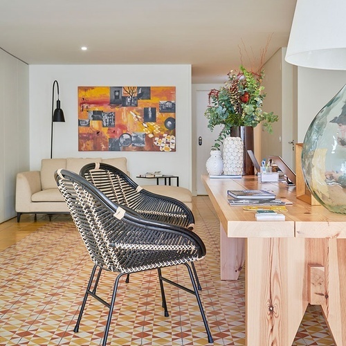 a living room with a table and chairs and a painting on the wall