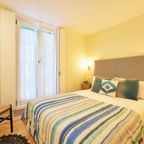 a bed with a blue and white striped blanket and pillows