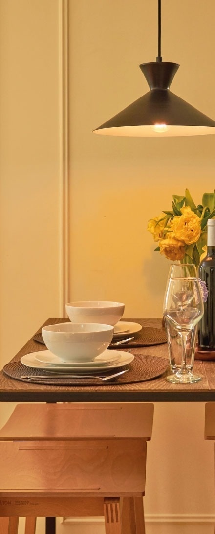 una mesa de comedor con platos y copas y un jarrón de flores