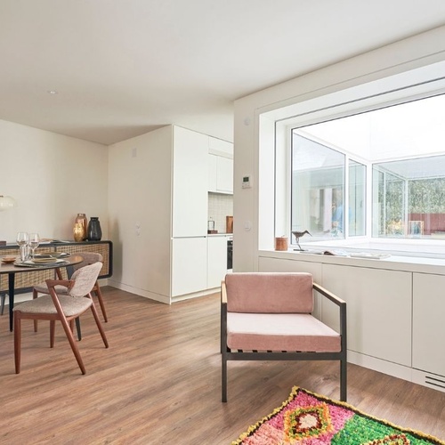 a living room with a table and chairs and a window