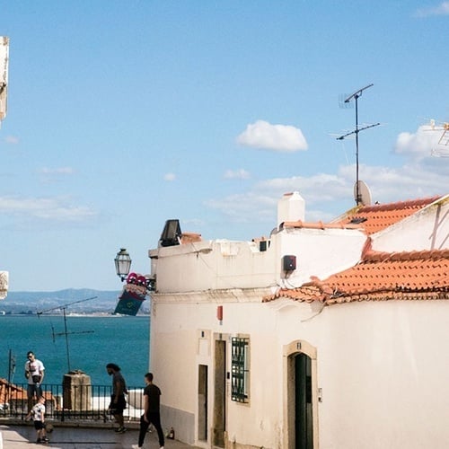 uma mulher e uma criança estão brincando em uma rua com um prédio branco ao fundo