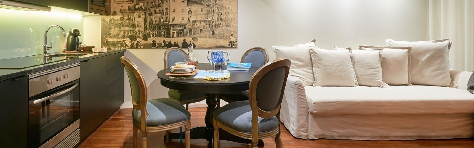 a kitchen with a table and chairs and a painting on the wall