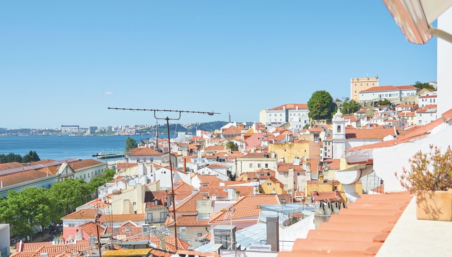 una vista de una ciudad con techos rojos y un océano en el fondo