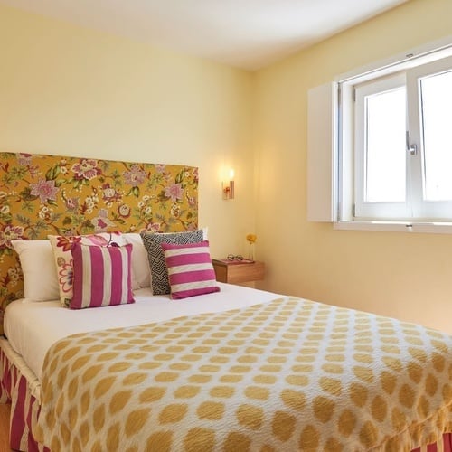 a bedroom with a bed and a window with shutters