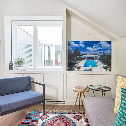 a living room with a blue couch and a colorful rug