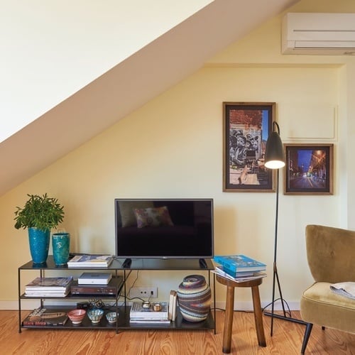 a living room with a flat screen tv and a chair