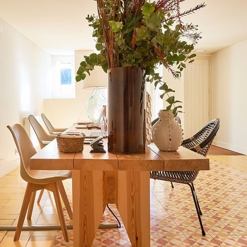 uma mesa de madeira com um vaso de flores sobre ela