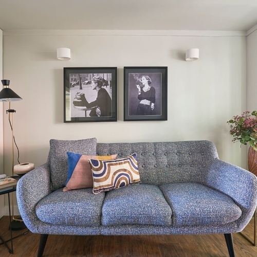 a bedroom with a bed and a dining room in the background