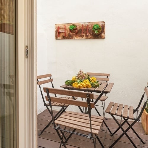 a patio with a table and chairs and a sign that says home