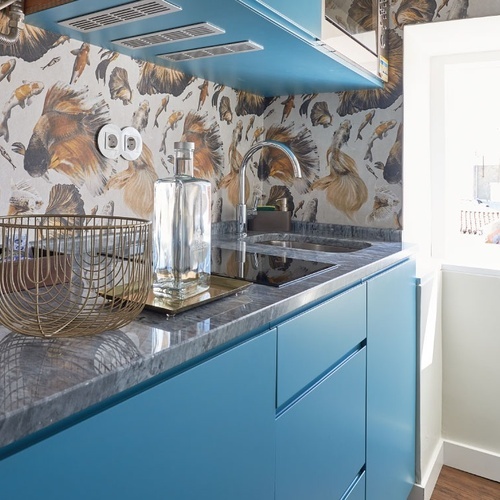 a kitchen with blue cabinets and a krups coffee maker