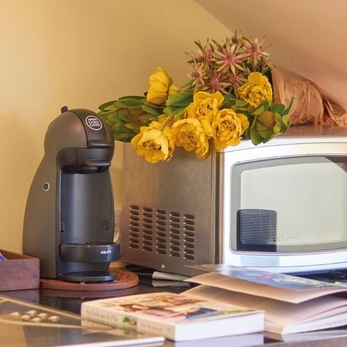 a krups coffee maker sits next to a microwave