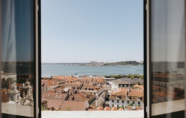 uma janela com vista para uma cidade e um corpo de água