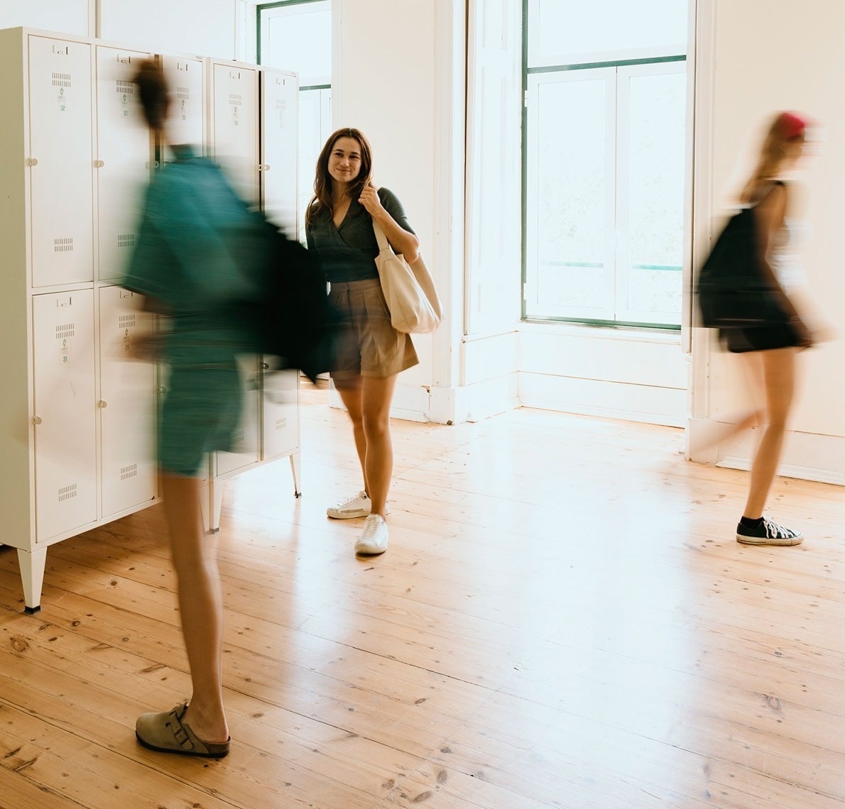 a woman standing in front of a row of lockers with the letter t on them