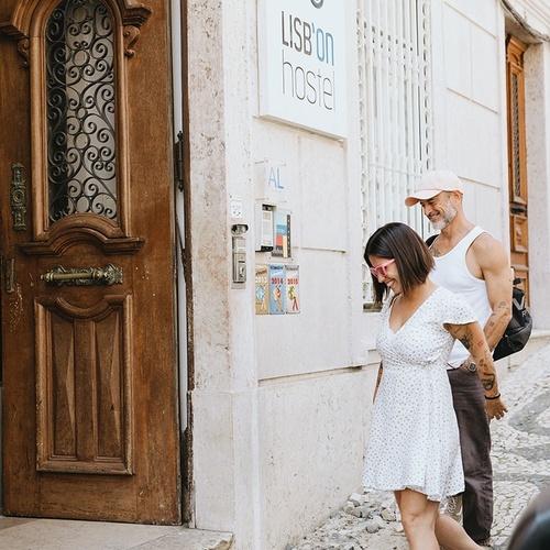 a man and woman are walking in front of a hostel