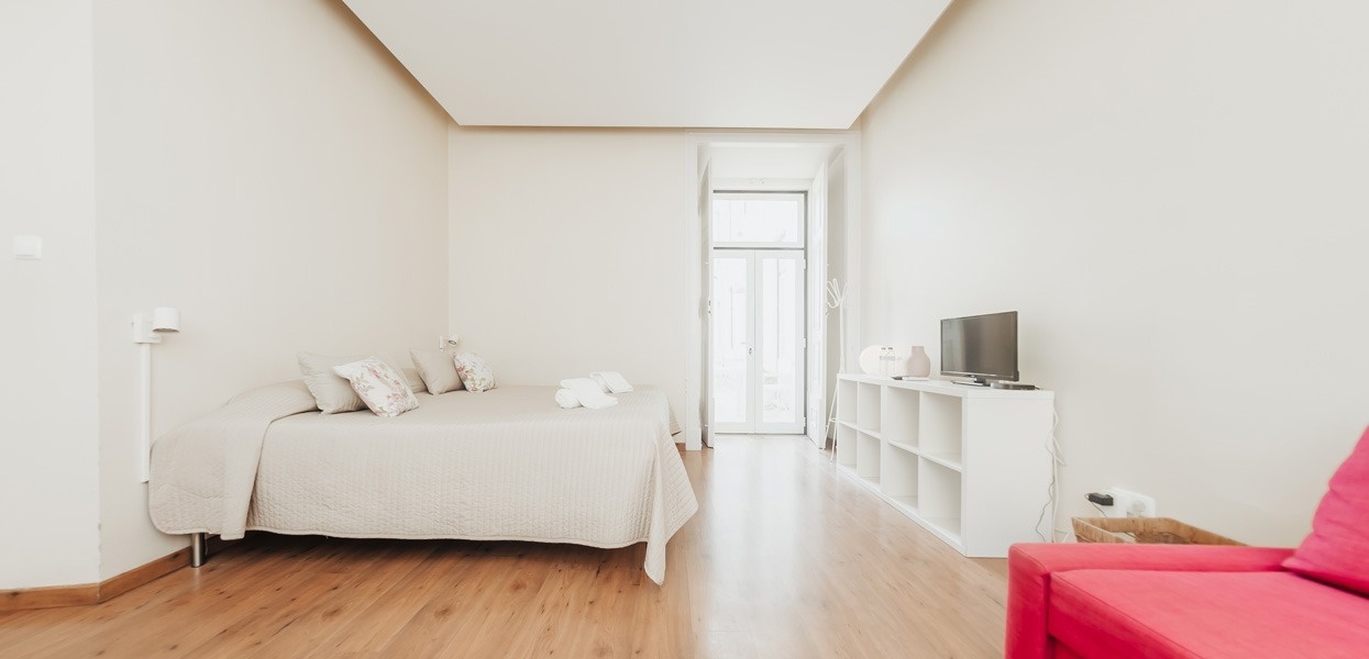 una habitación blanca con una cama y una televisión