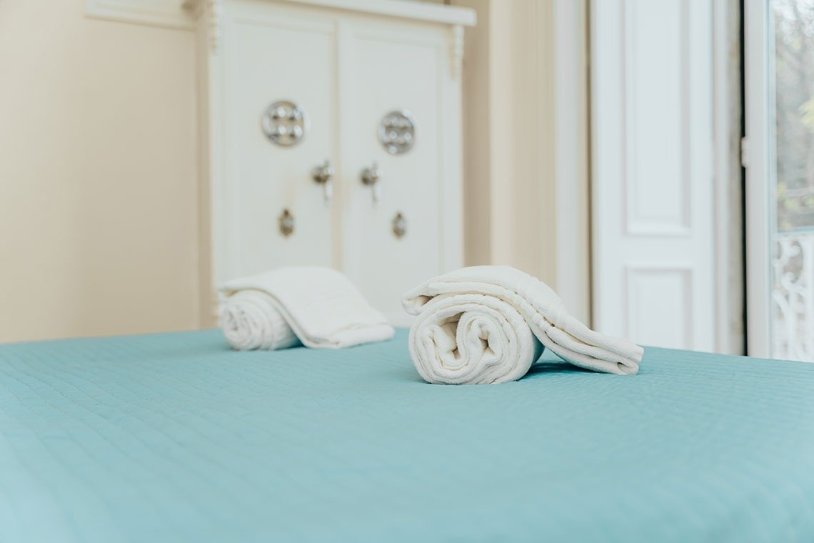 two towels are rolled up on a bed in a room