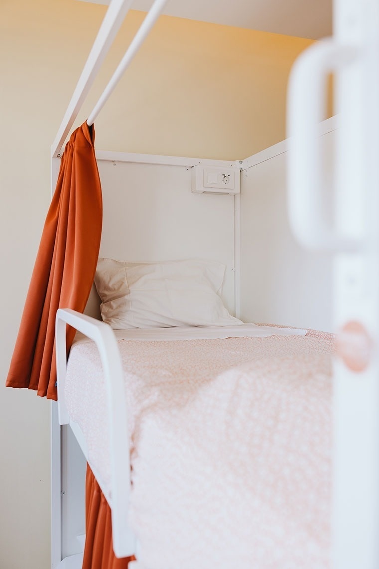 a bunk bed with a red curtain hanging over it